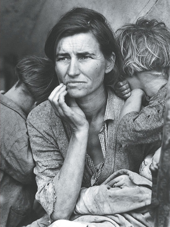 Photo of a mother in tattered clothes with two young children.