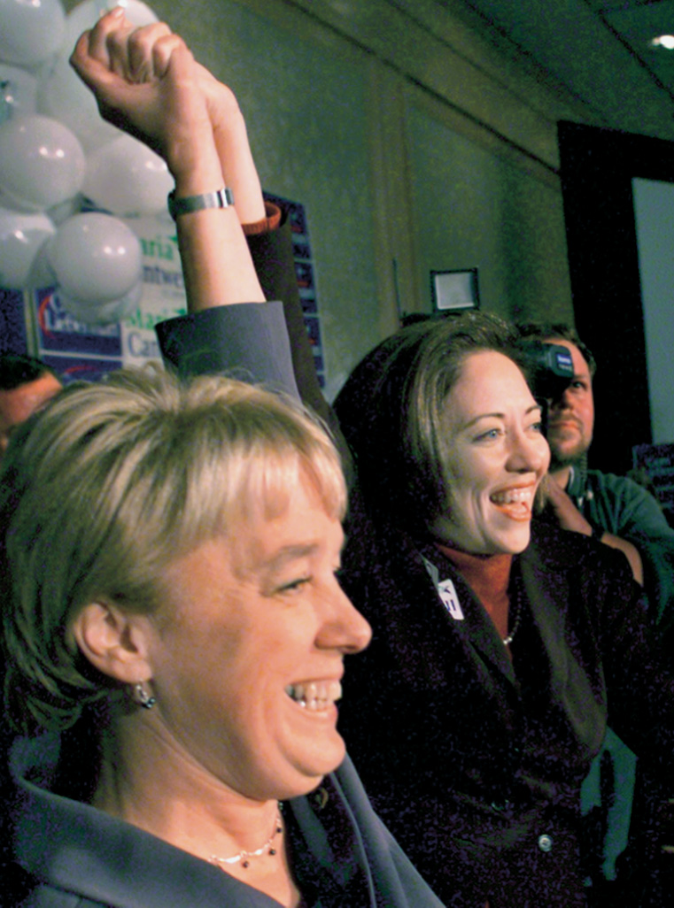 Two women raise their hands in victory.