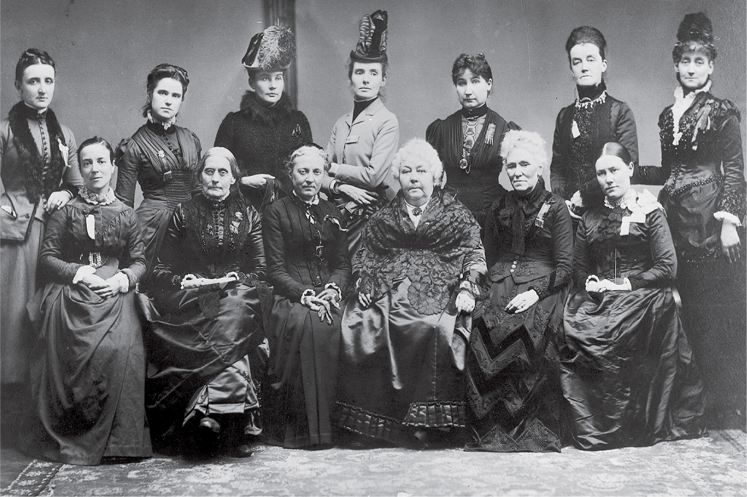 13 women pose
toegther in a black and white photo.