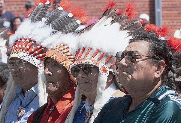 A recent photo shows Native American men wearing traditional feathered headdresses.