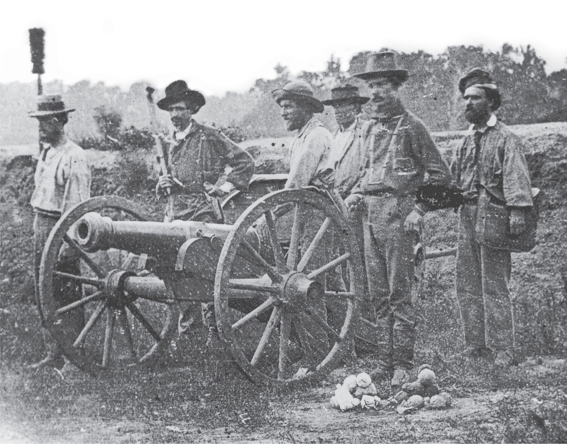 A photo: men stand by a cannon.