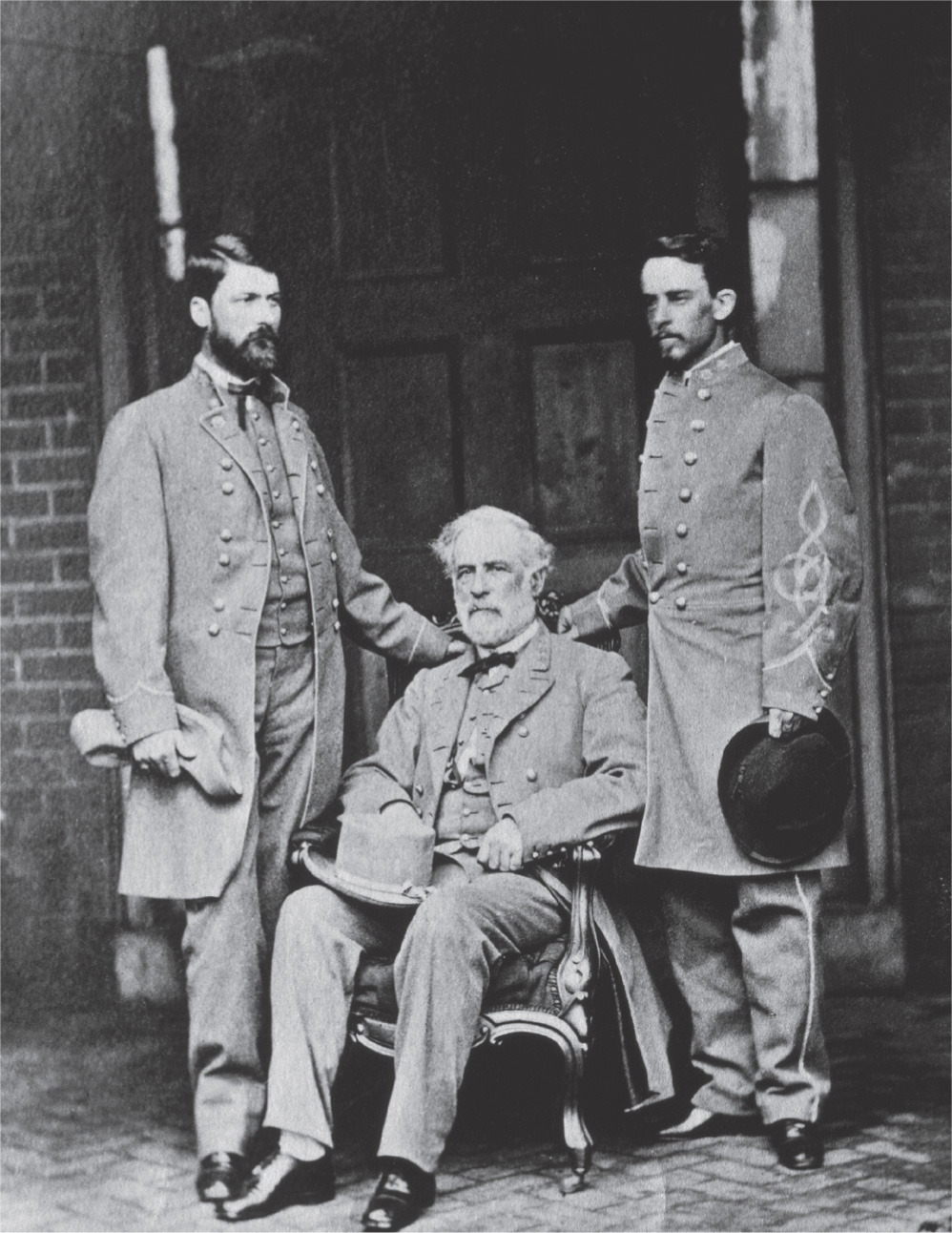 In a photo, two Confederate officers stand by Lee.