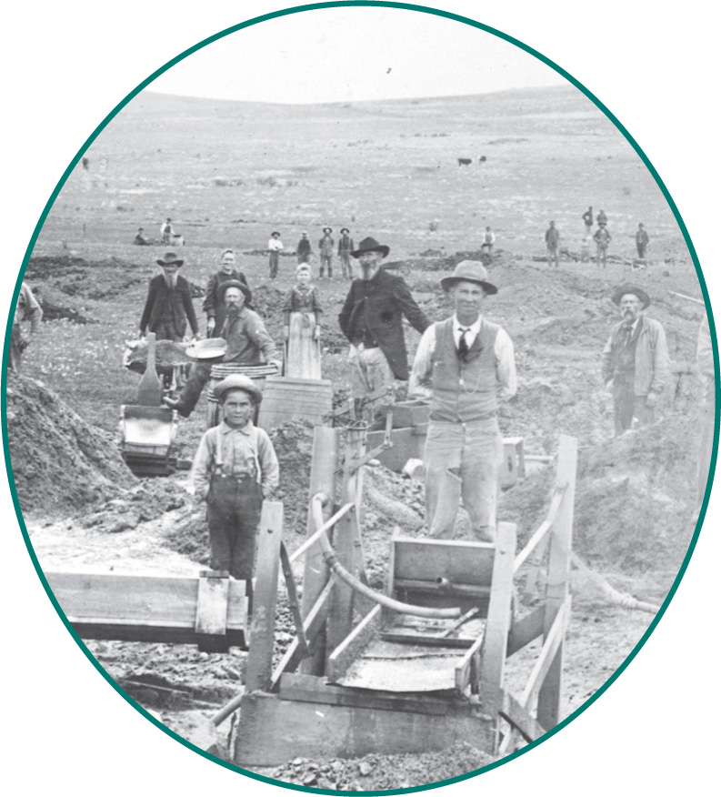A photo: prospectors stand by sluices at a mine.