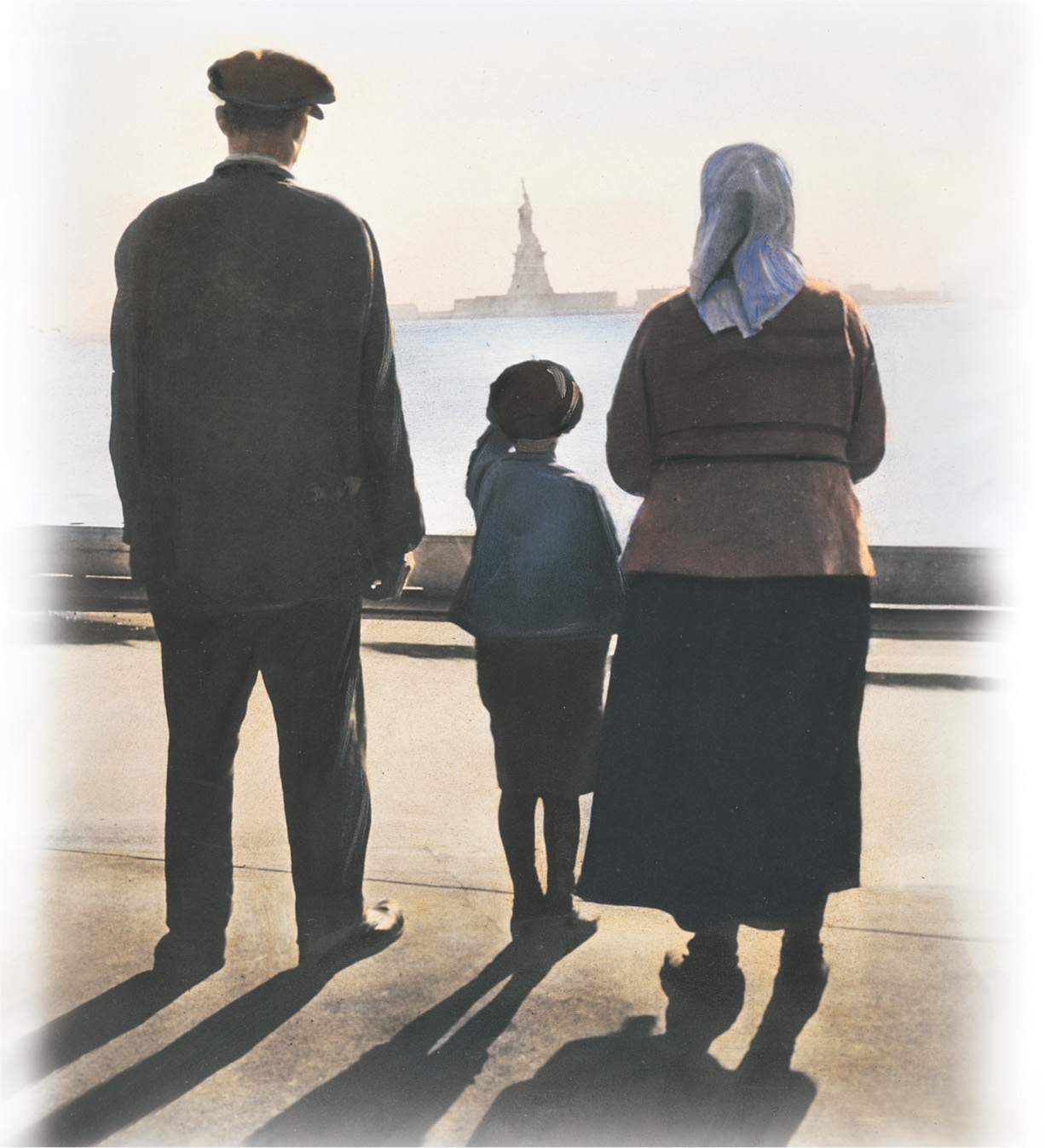 A photo: a family stares at the Statue of Liberty.