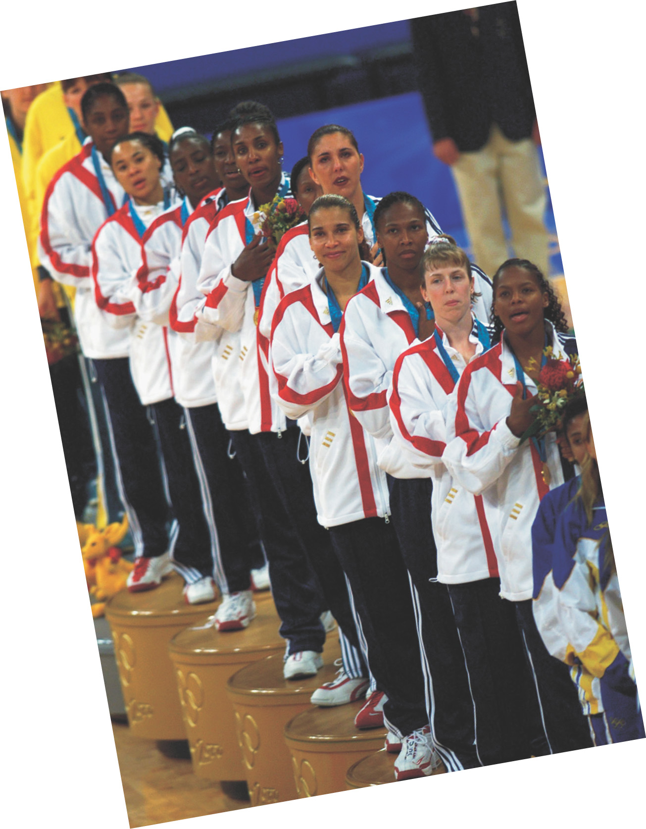 A photo: African-American, white and Asian women athletes wear gold medals.