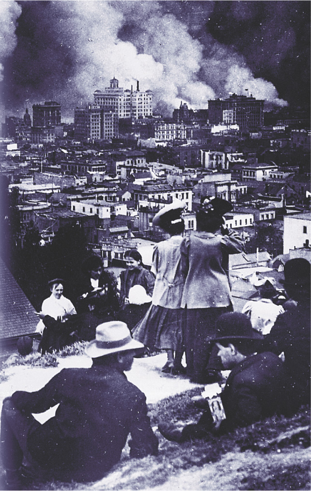 A photo: people on a hilltop watch as buildings crumble in the San Francisco Earthquake.