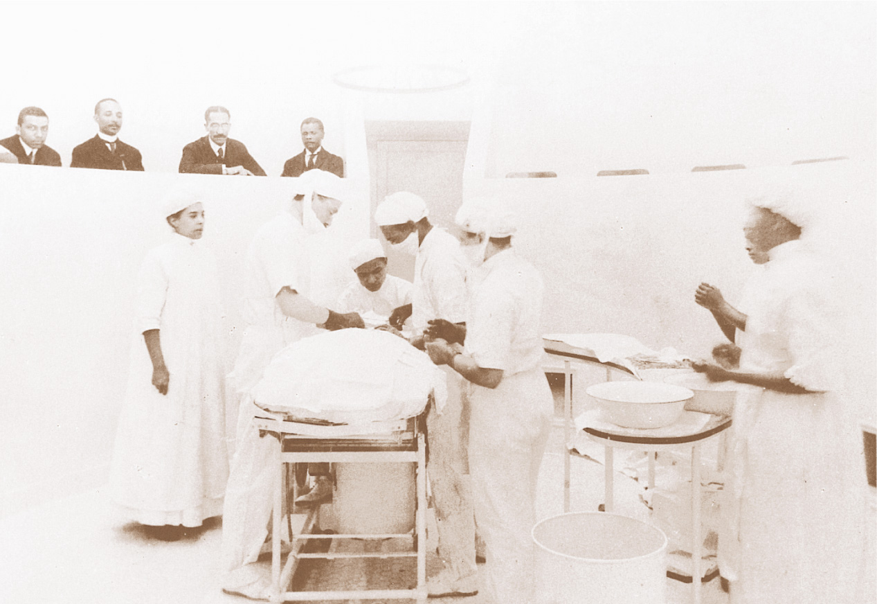 A black-and-white photo: African-American medical students and professors work in an operating theatre.
