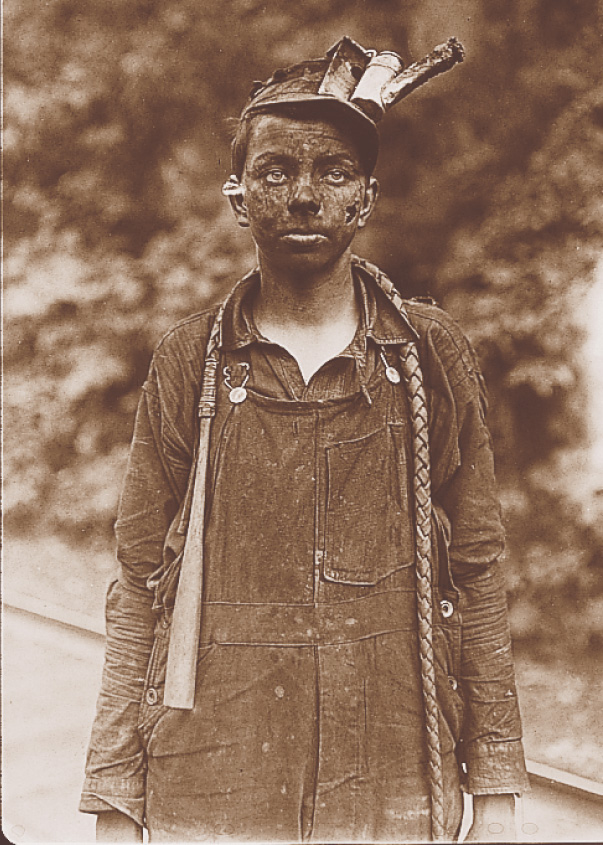 Photo: A grimy boy with a face blackened by coal dust