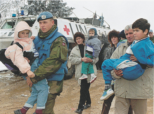 Photo: Soldiers and refugees carry children past a UN tank