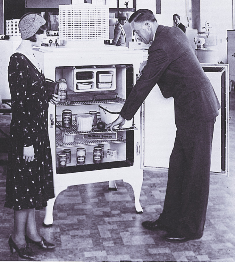 Photo: a salesman shows a customer a refrigerator