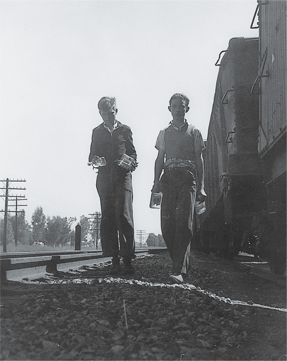 Photo: two boys walking along railroad tracks