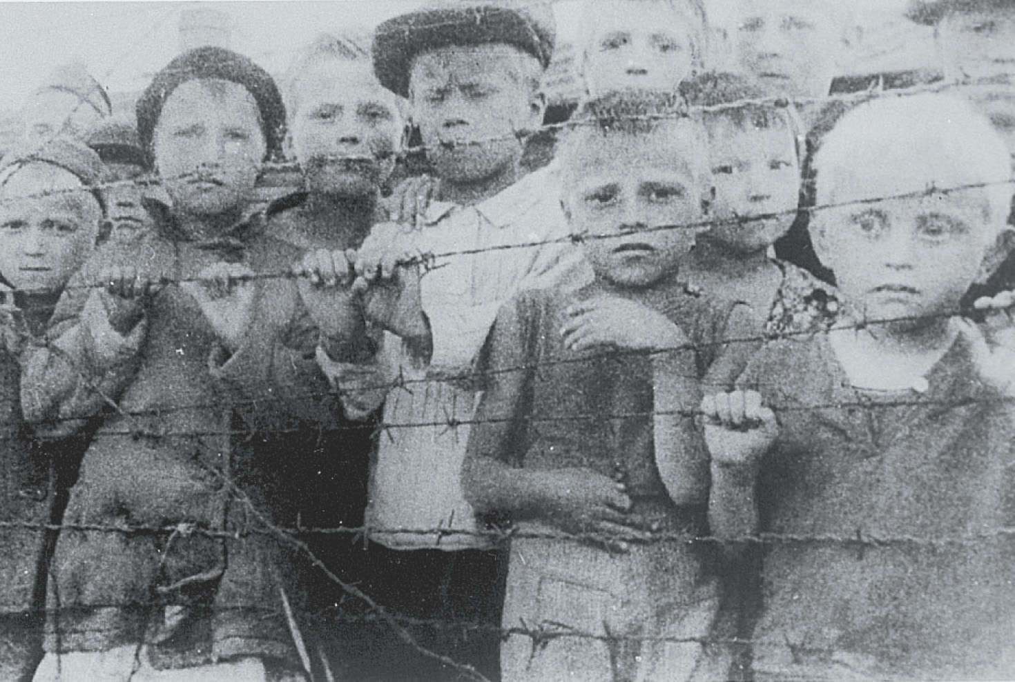 Photo: children behind a barbed-wire fence