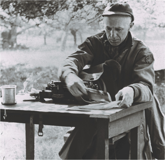 Photo: Ernie Pyle at work at an outside table