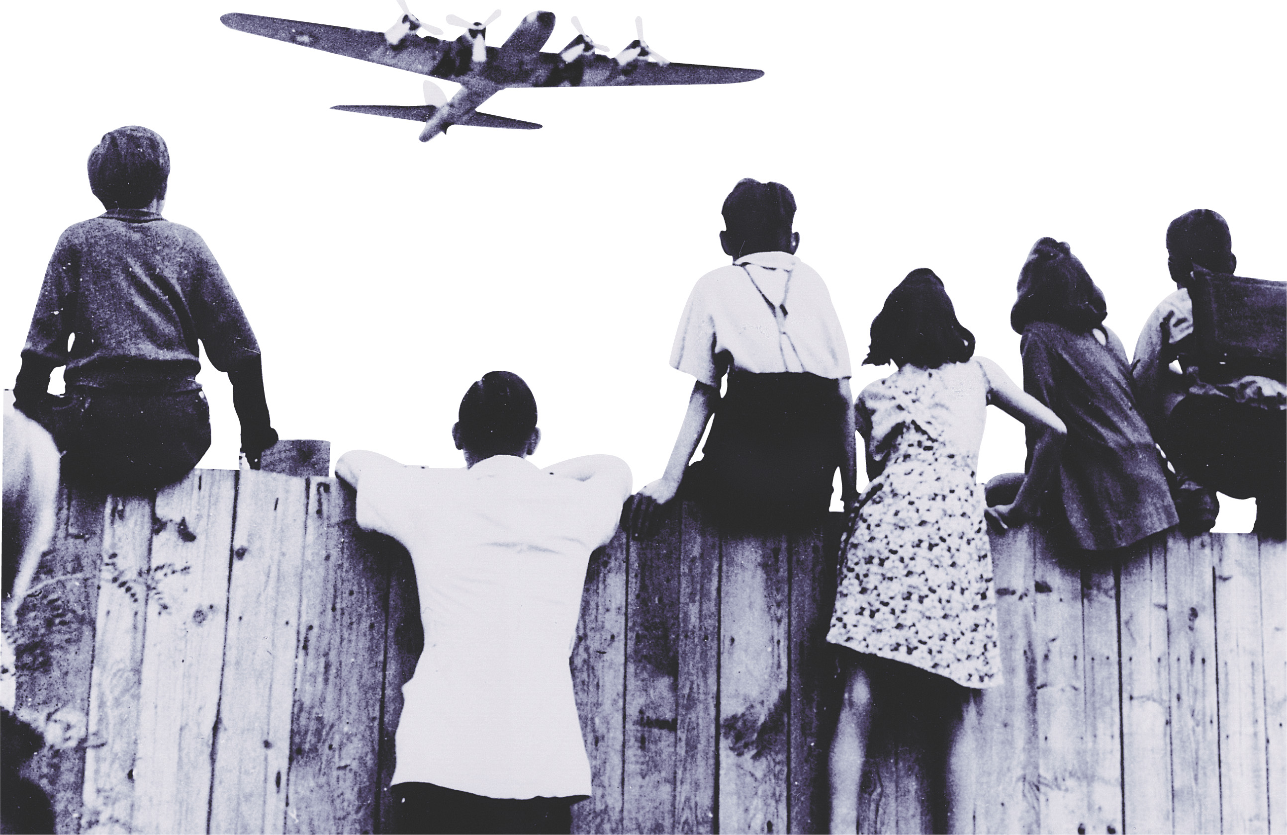Photo: Children sit on a fence, watching a plane fly low overhead