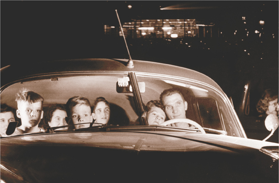photo: family in a car at a drive-in movie