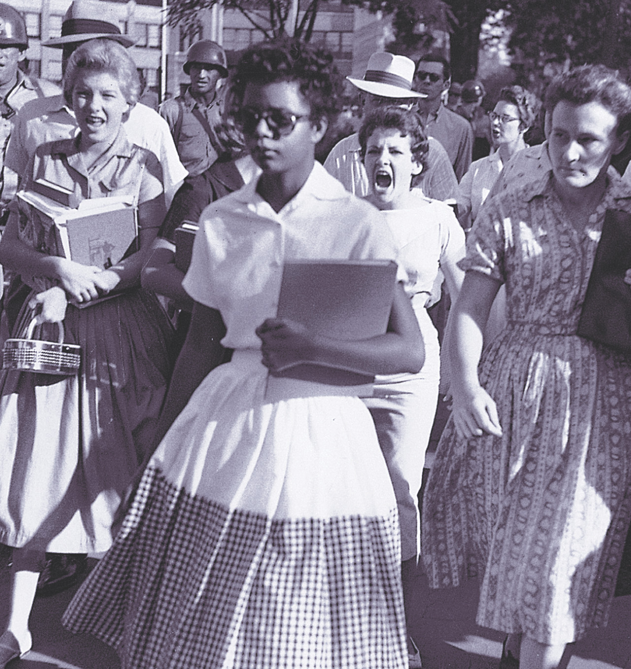 photo: An African American girl carries a notebook as she walks past screaming white people.