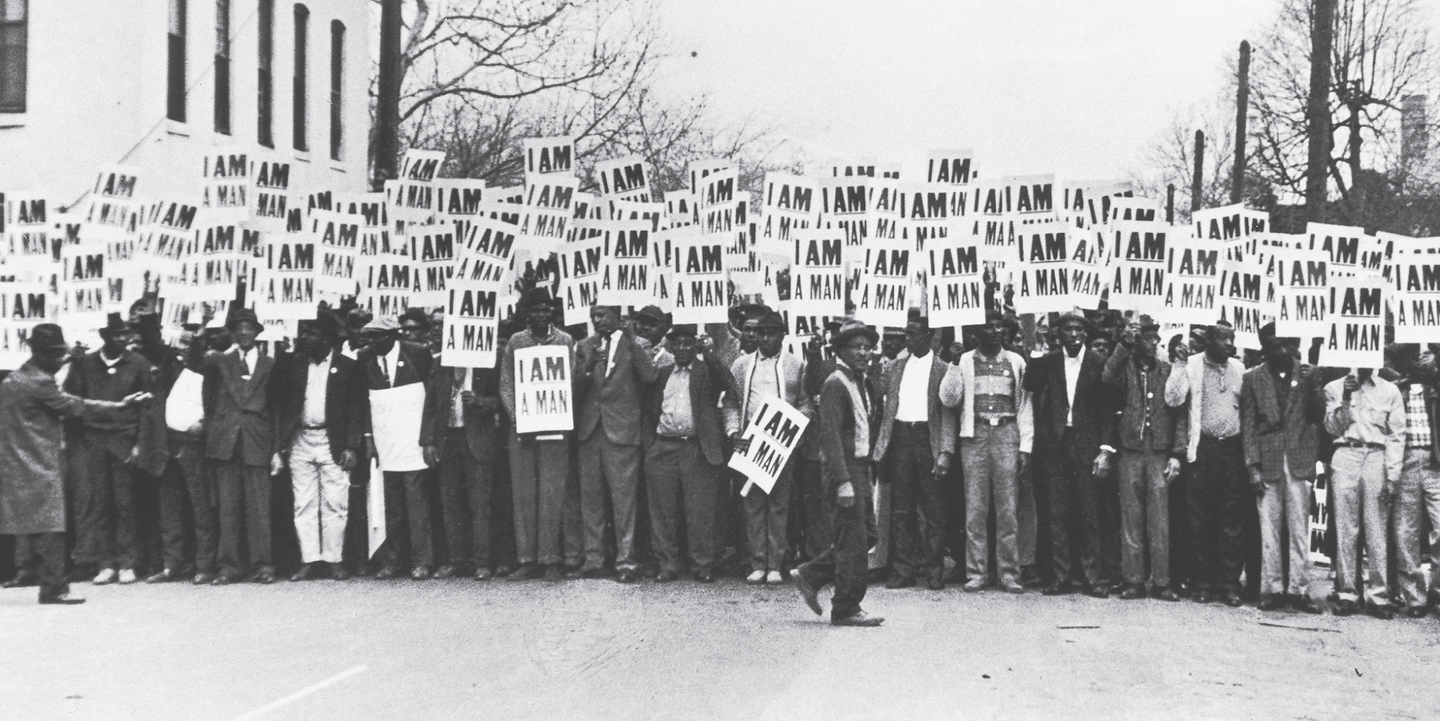 photo: dozens of African American men stand together, holding signs that read I Am a Man.