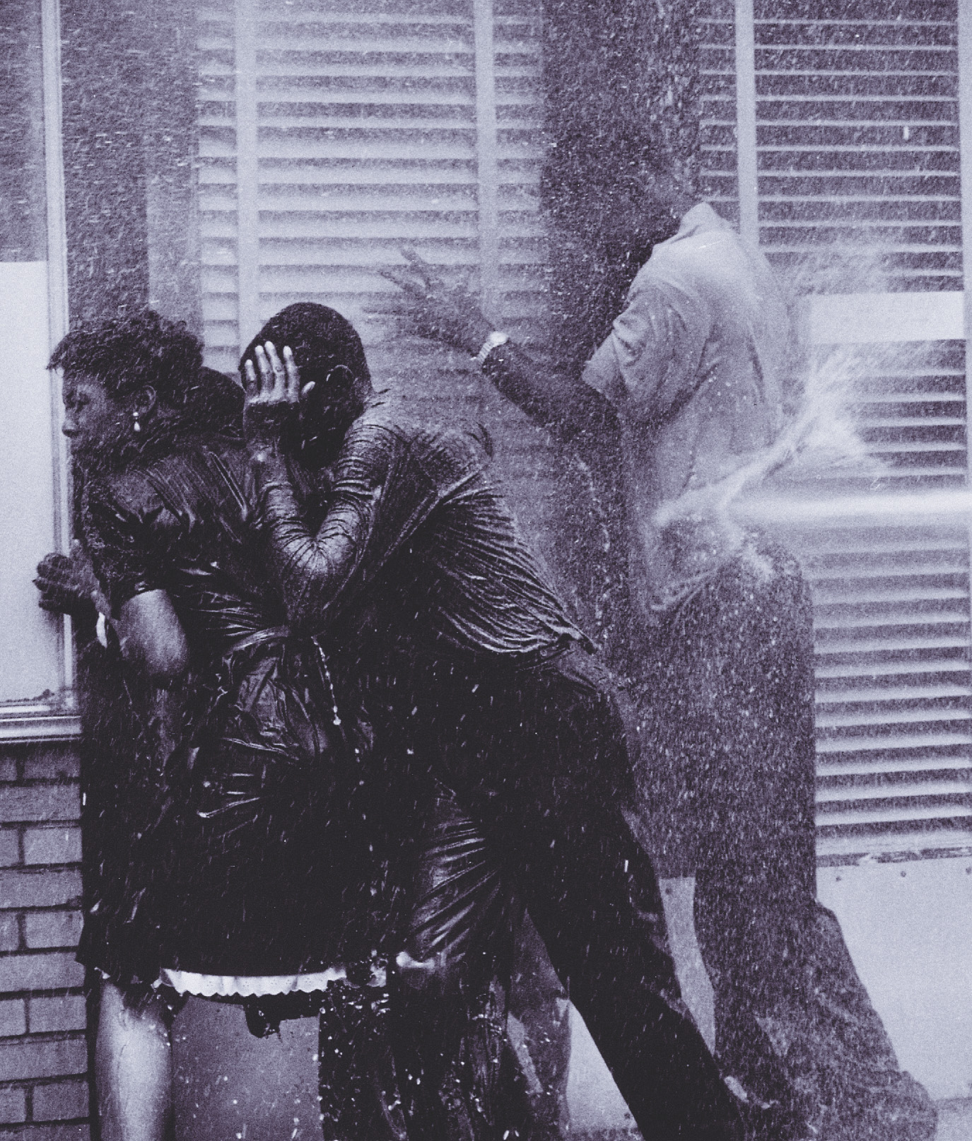 photo: water sprayed from a hose hits a group of African-Americans.