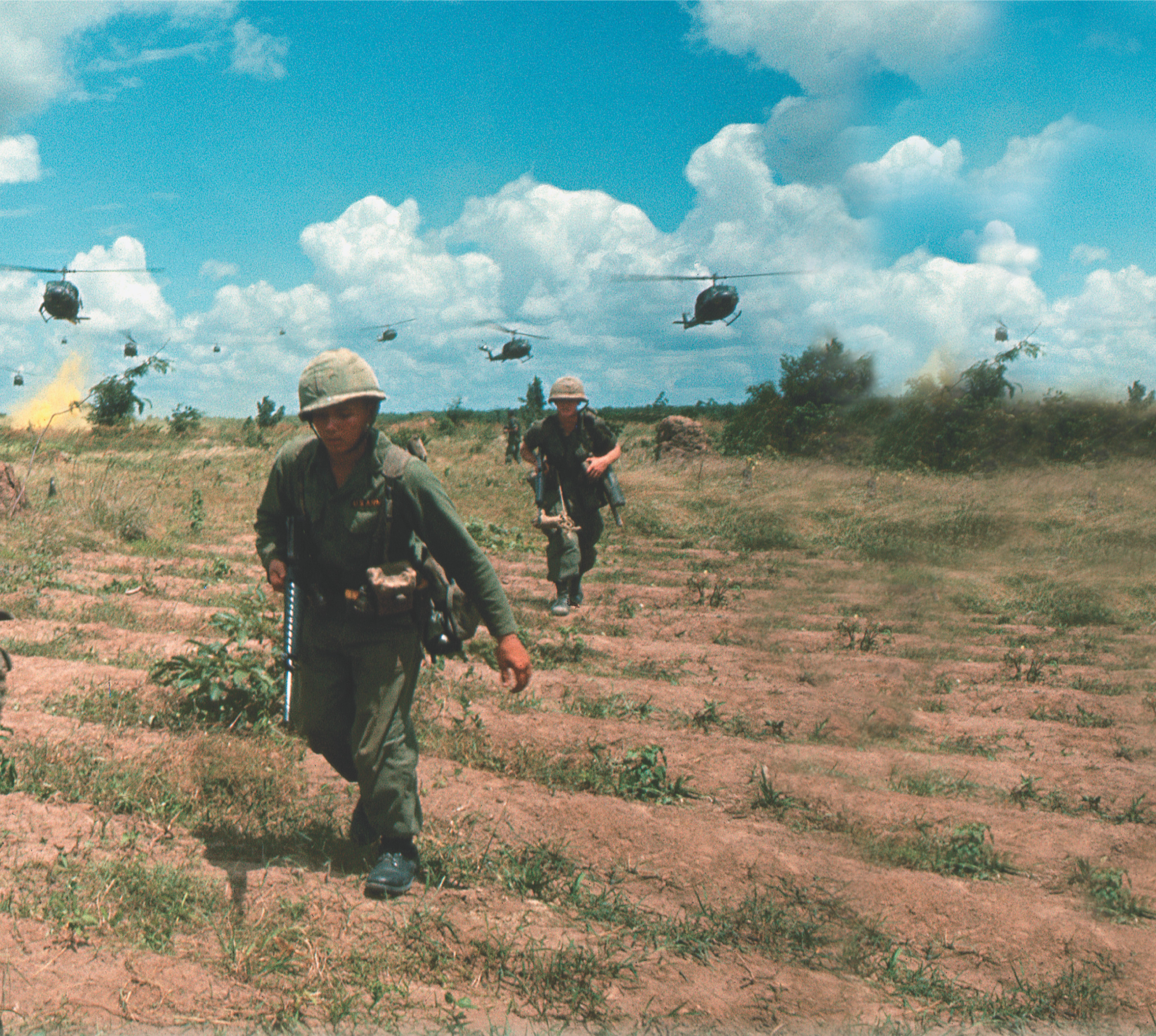 photo: soldiers walk across a field, while helicopters fly low overhead. A title: The Vietnam War Years.