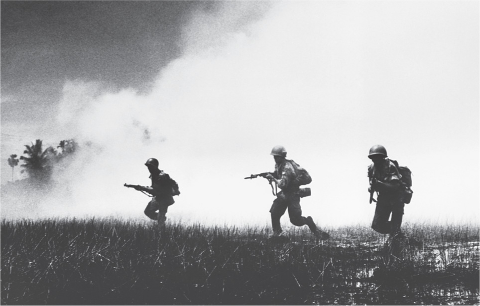 photo: soldiers charge through a cloud of white smoke.