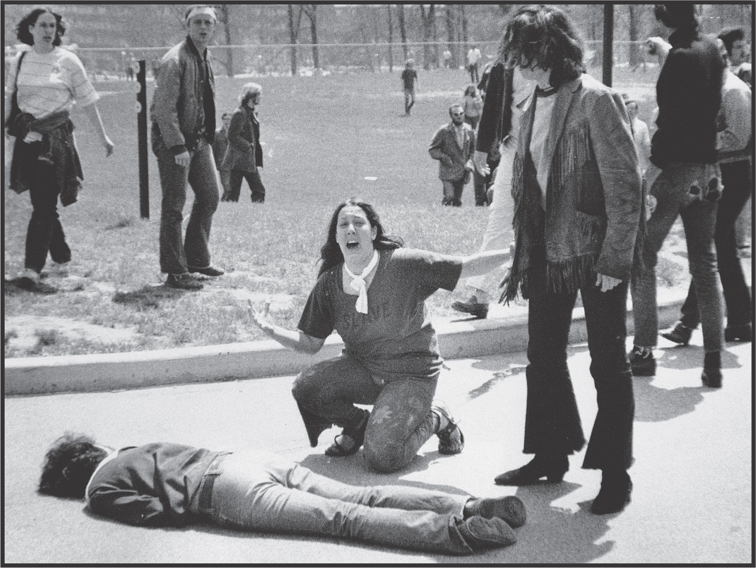 photo: Her mouth gaping, a young woman kneels over a man lying on the ground.