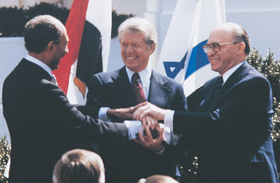 photo: Jimmy Carter, Menachem Begin and Anwar el-Sadat smile and join hands.