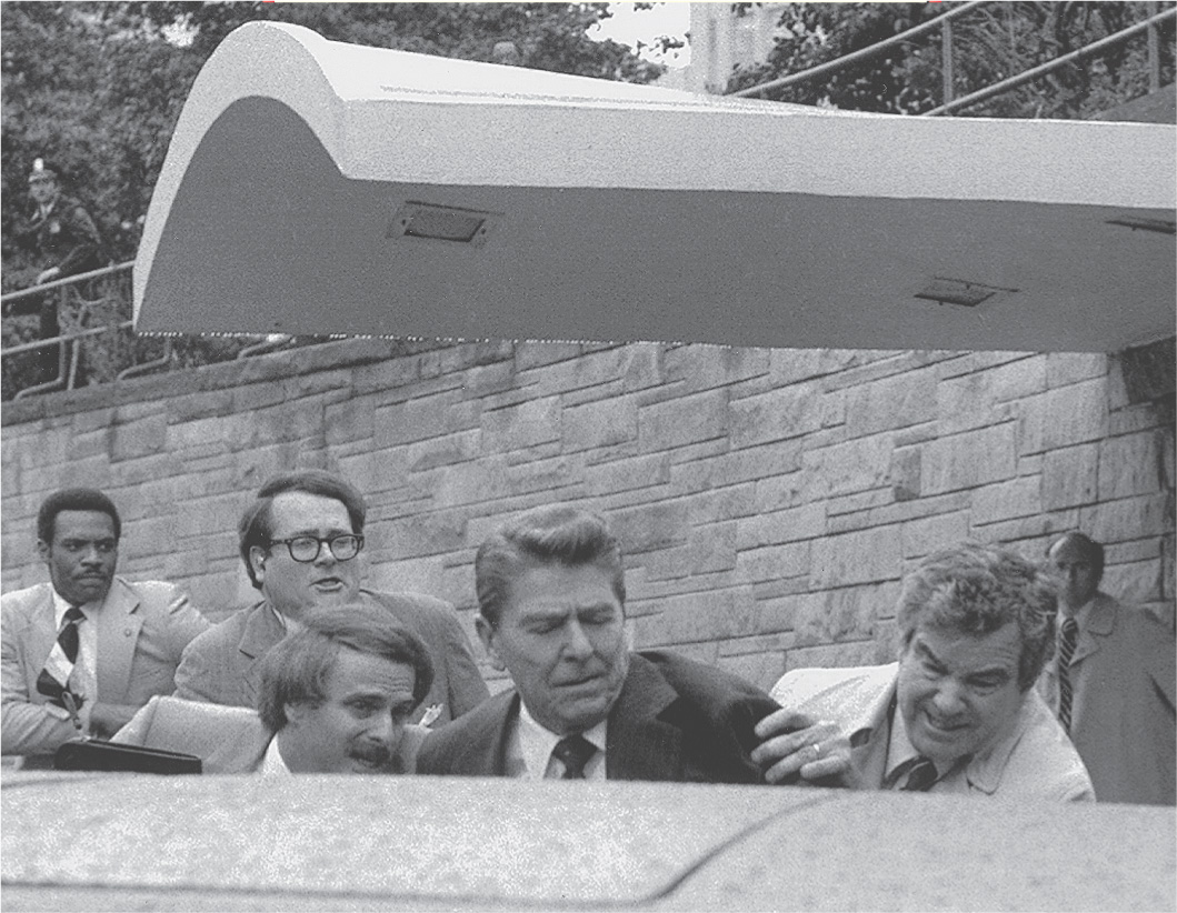 photo: aides push Reagan into a car.