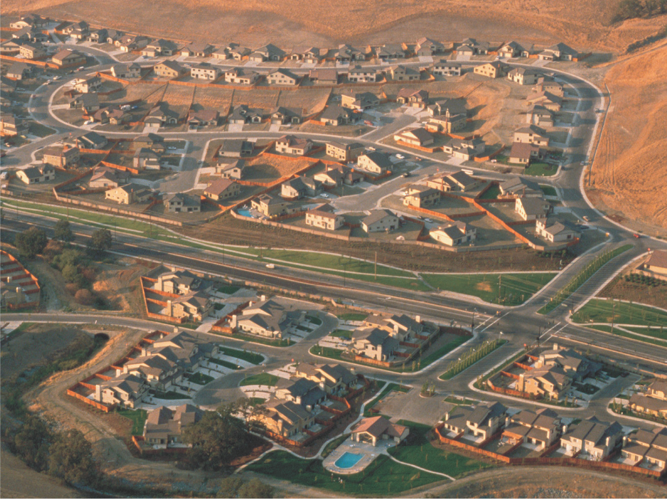 An aerial photo: houses line suburban streets and cul-de-sacs.