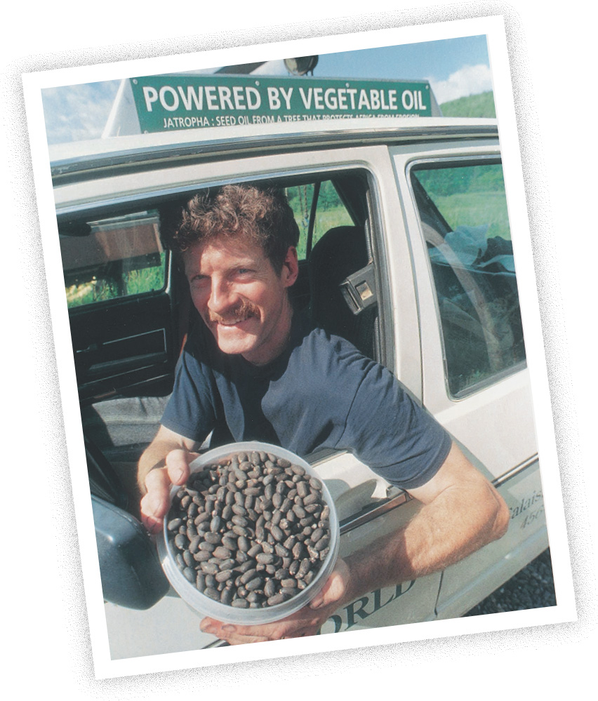photo: a man in a car holds a bowl of seeds. A sign reads 'Powered by Vegetable Oil.'