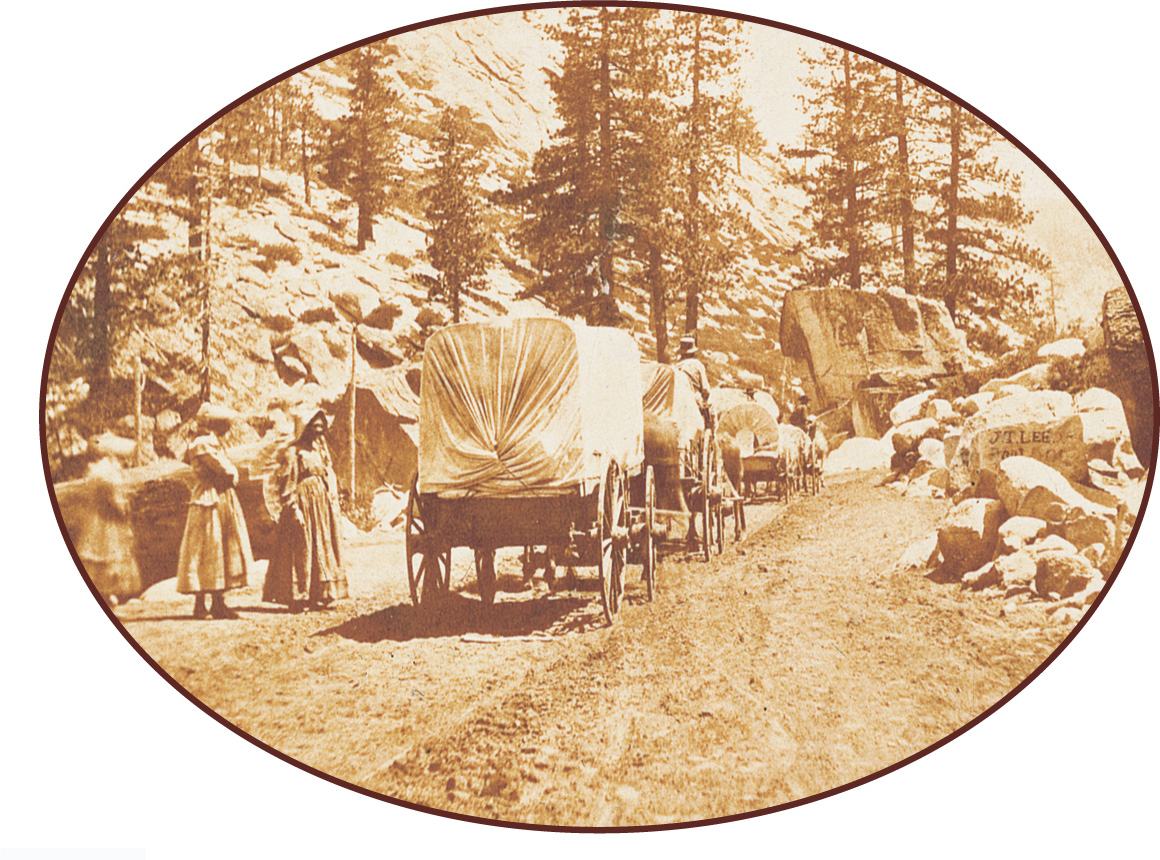photo: covered wagons roll along a trail.