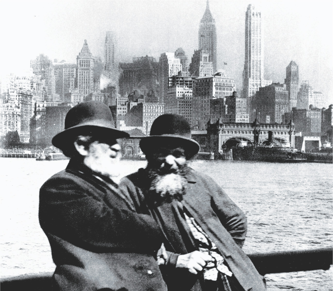 photo: two men with long beards stand by the ocean, with New York's skyline in the distance.