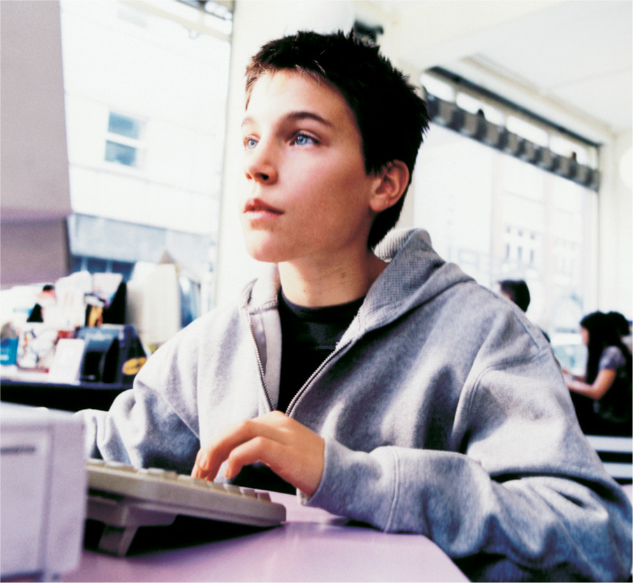 photo: a teenager types at a computer.