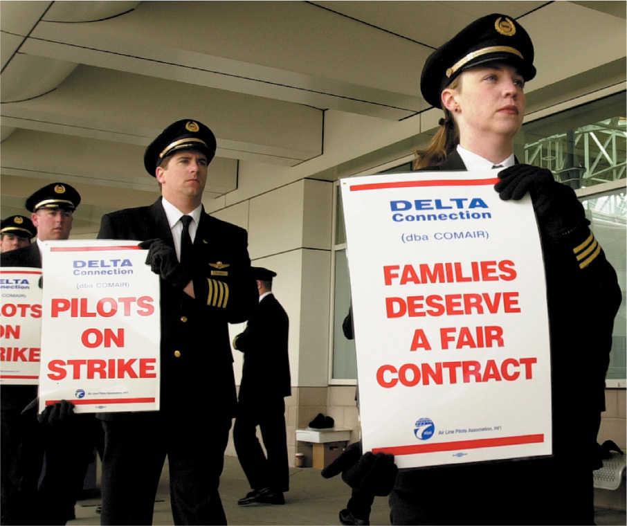 photo: Airline pilots carry signs: Pilots on Strike.